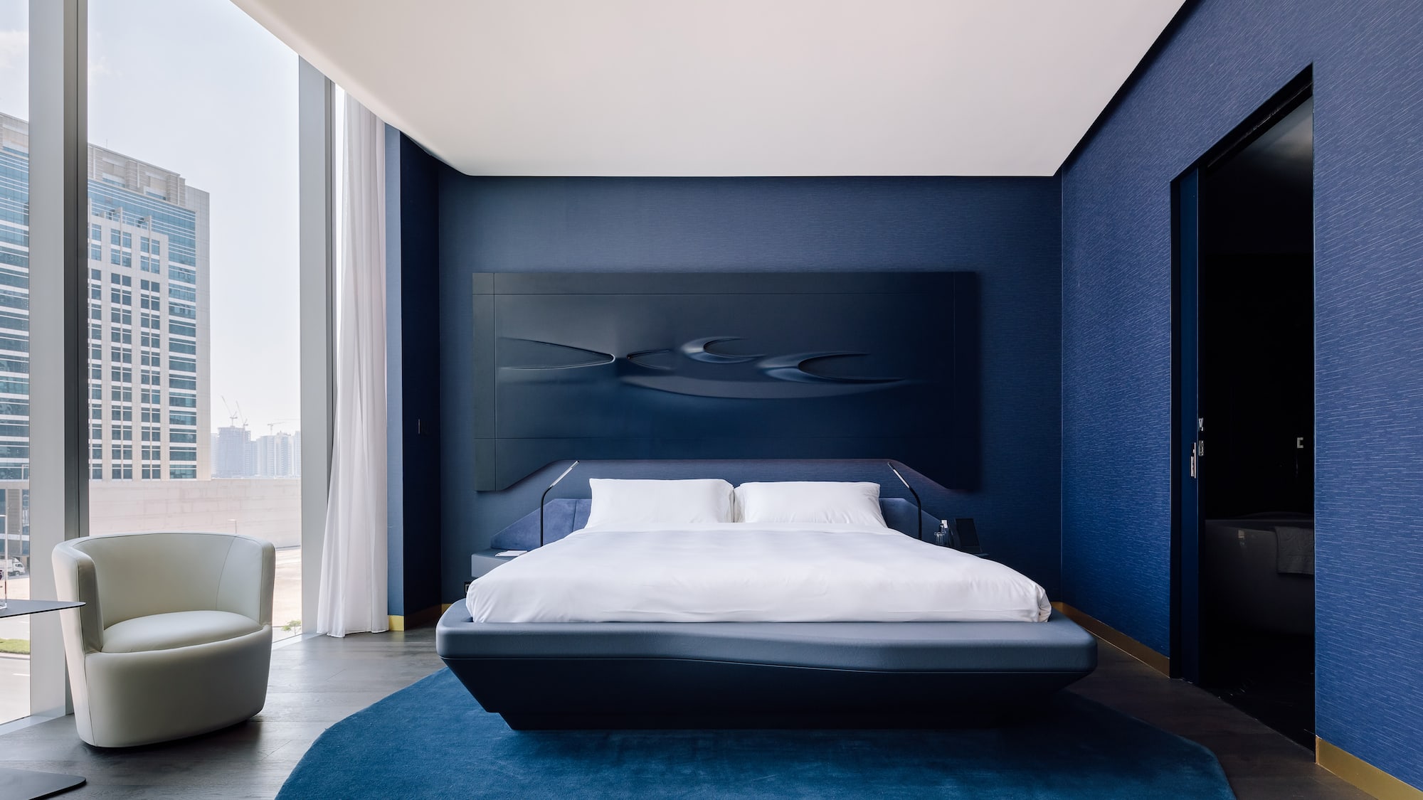 a bedroom with a bed and a blue wall