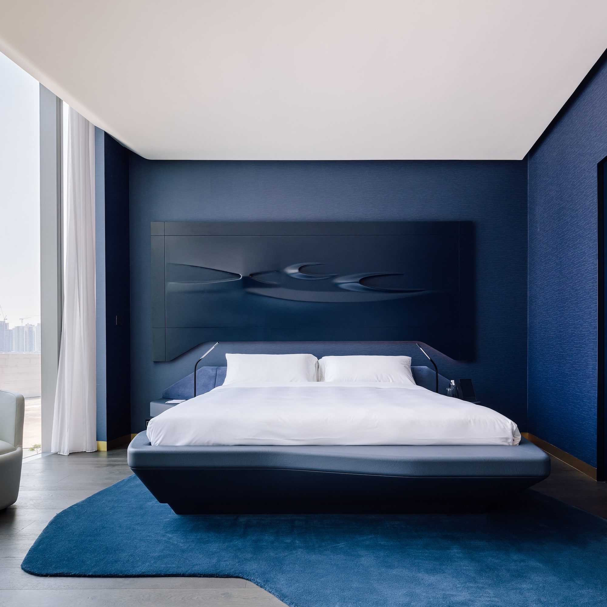 a bedroom with a bed and a blue wall