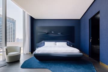 a bedroom with a bed and a blue wall