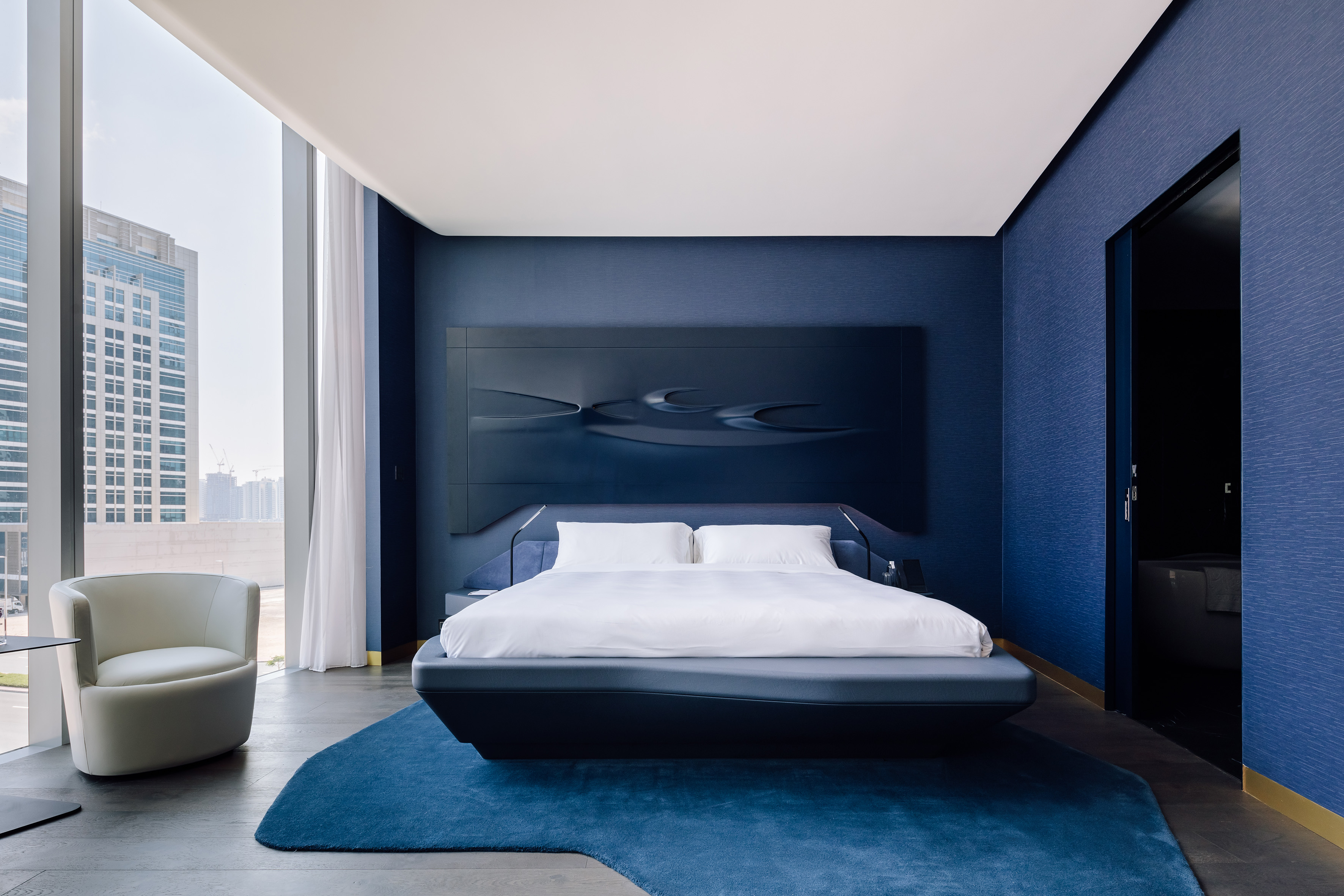 a bedroom with a bed and a blue wall