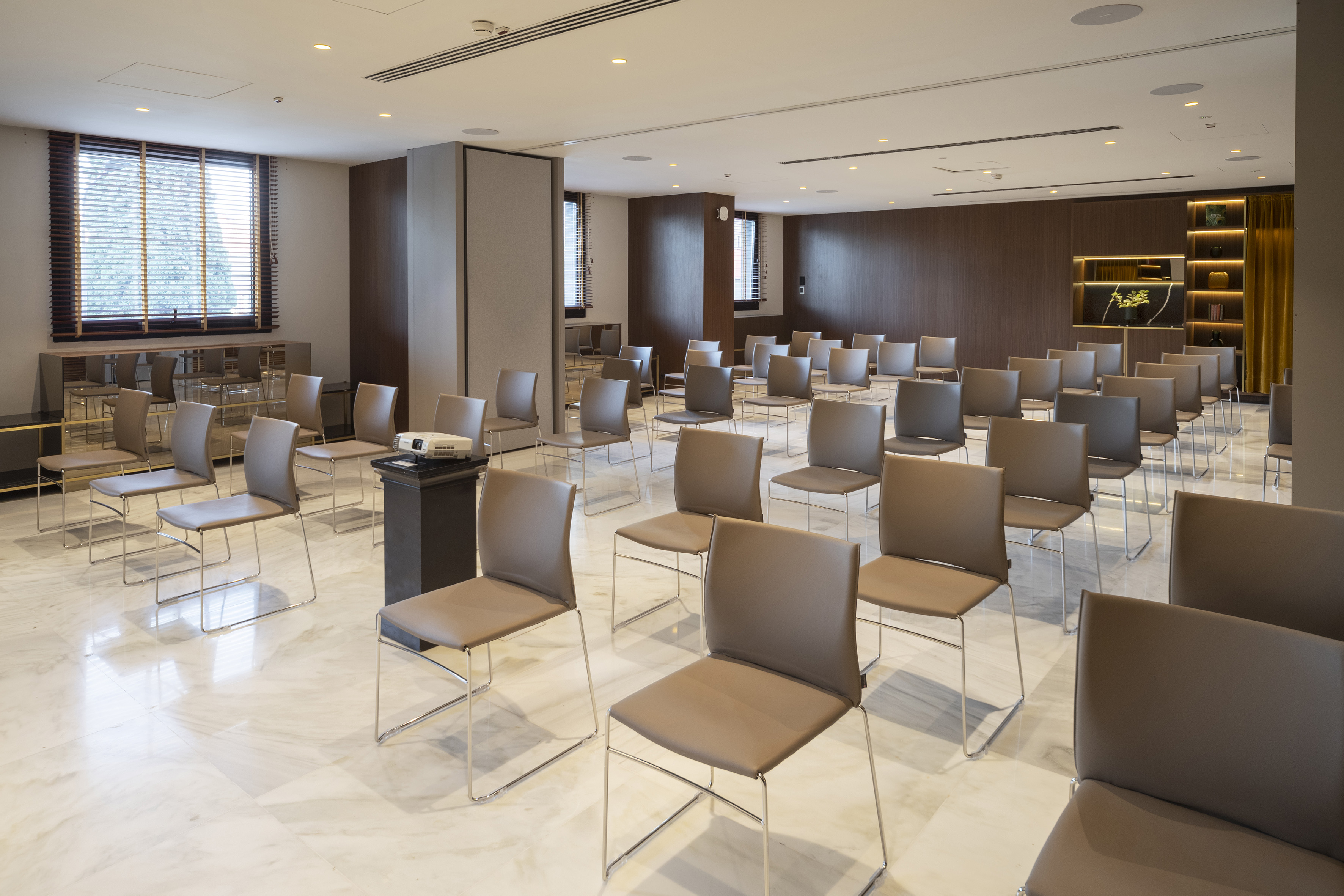 Modern conference room with rows of chairs and projector setup.