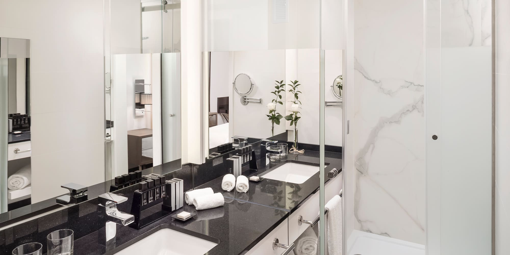 a bathroom with marble counter tops and white towels