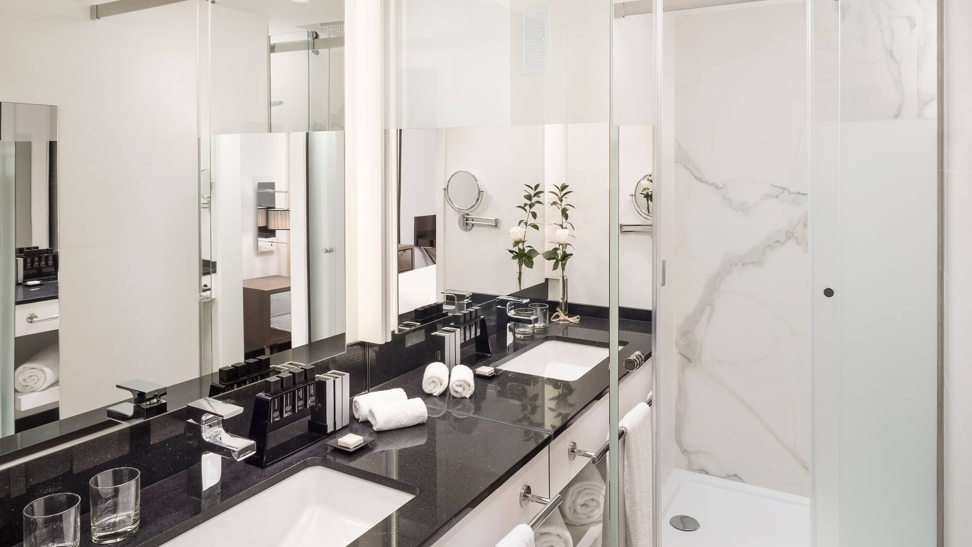 a bathroom with marble counter tops and white towels