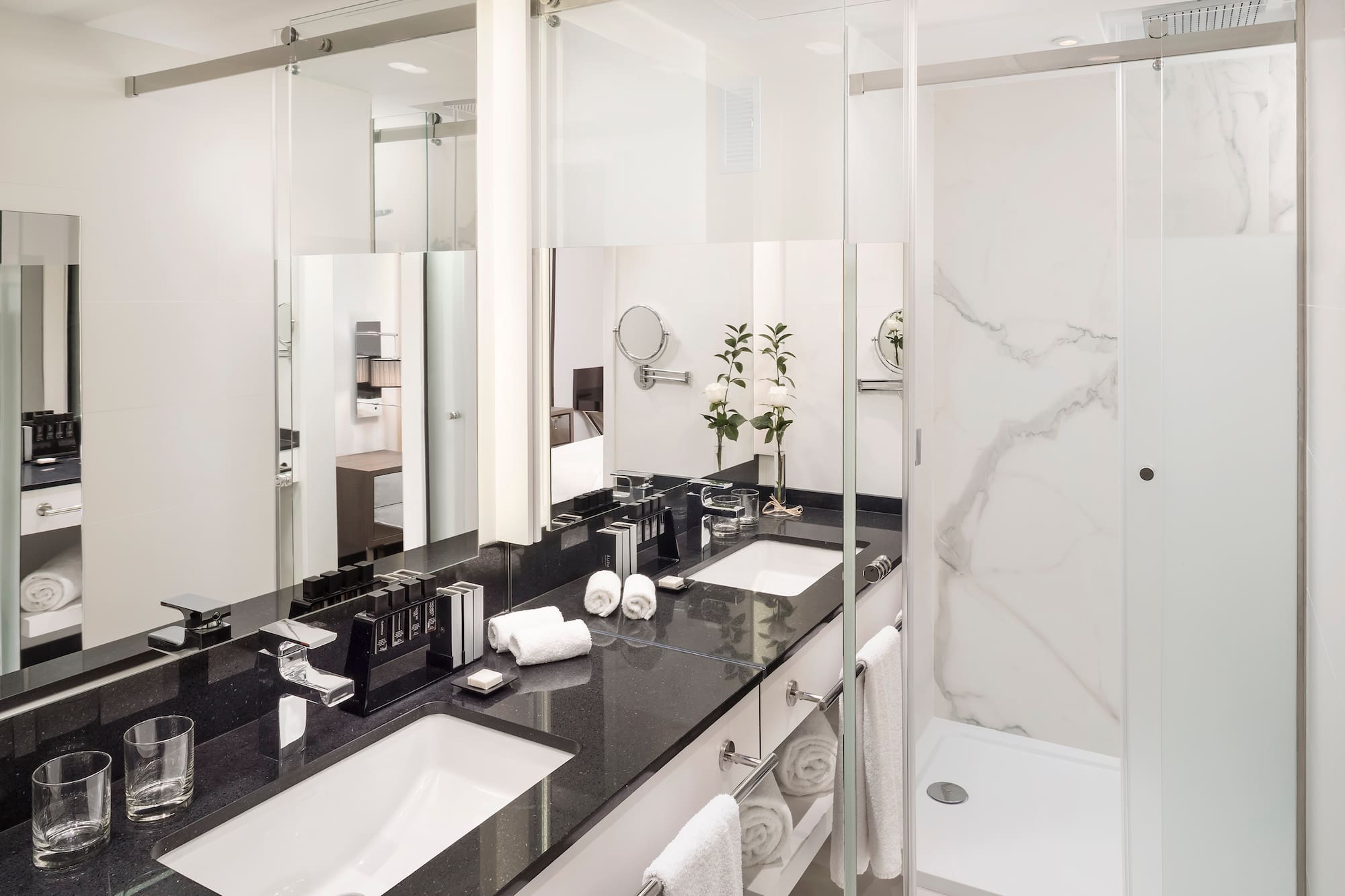 a bathroom with marble counter tops and white towels