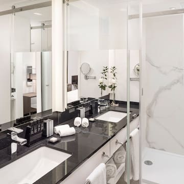 a bathroom with marble counter tops and white towels