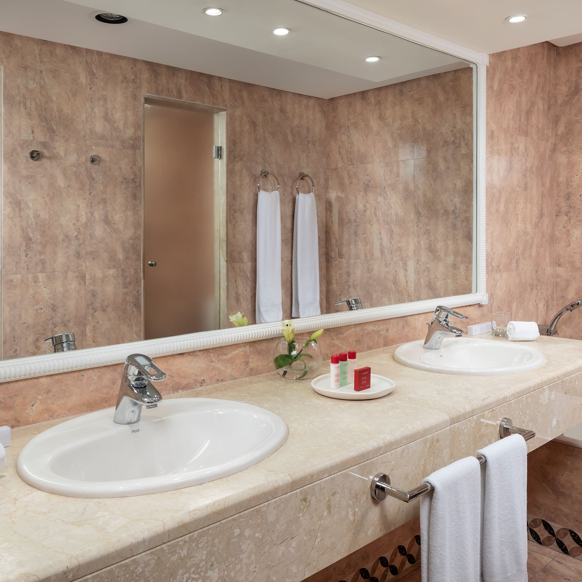 a bathroom with double sinks and a mirror