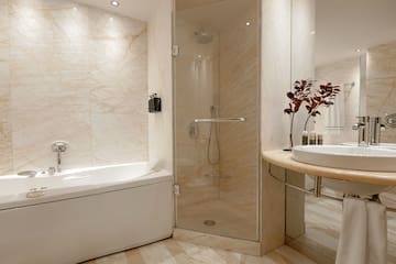 a bathroom with a glass shower and tub