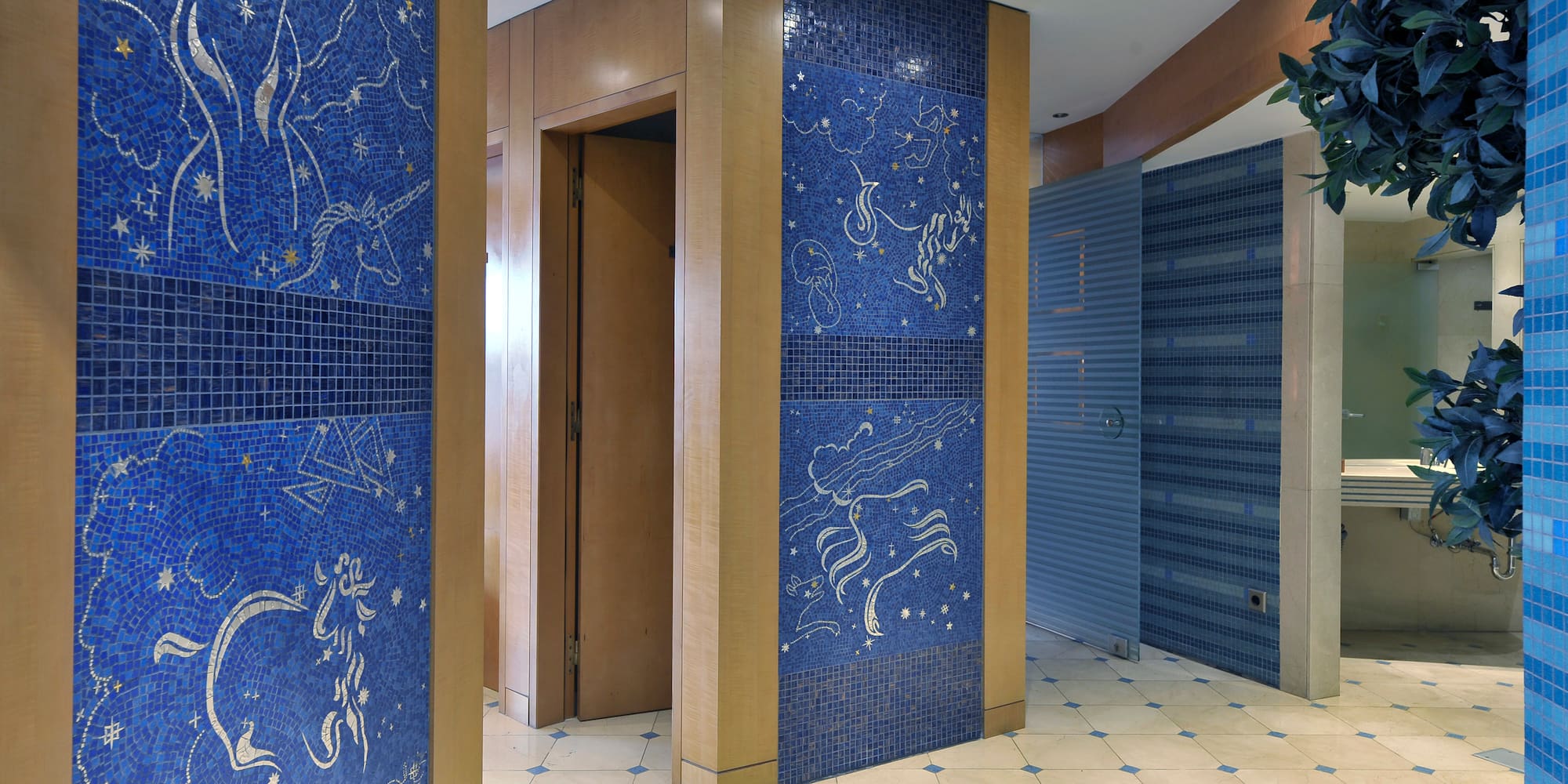 a blue tile wall with a white tile floor