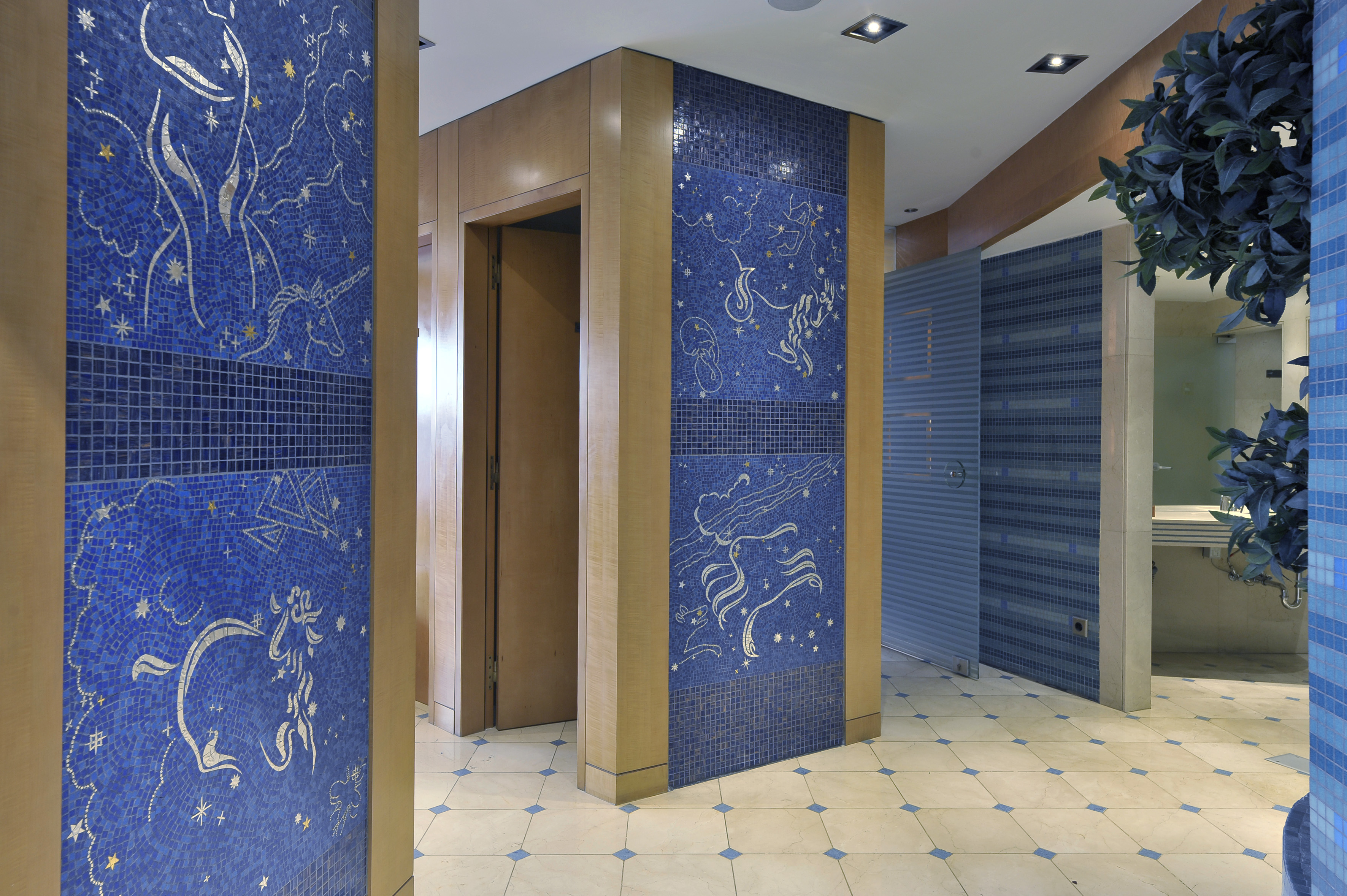 Modern restroom with blue mosaic tiles featuring unicorns and stars.