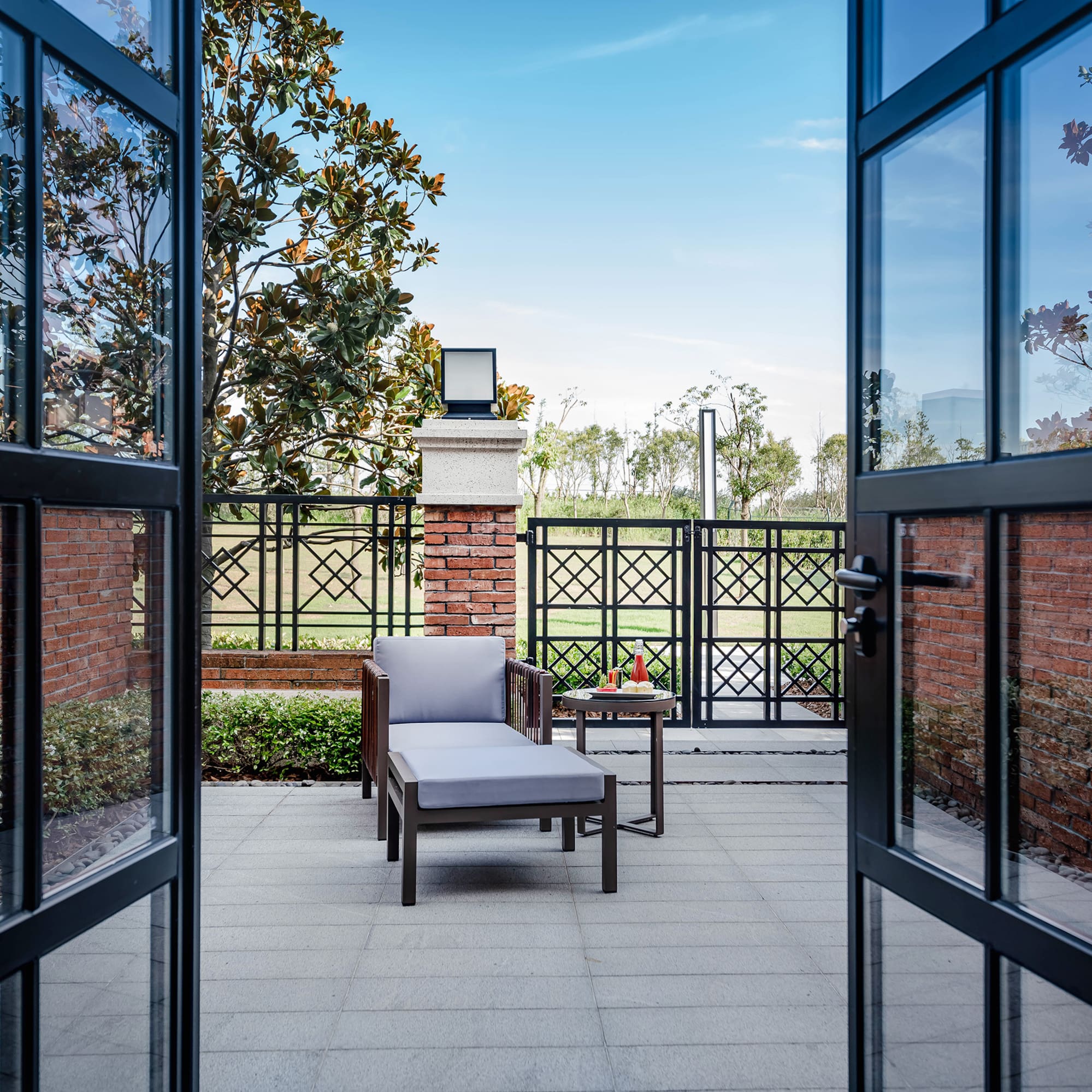 a chair and table outside with glass doors