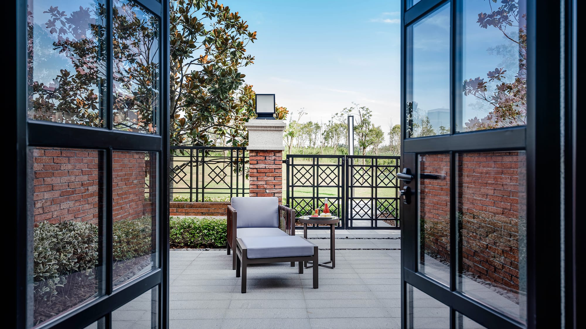 a chair and table outside with glass doors