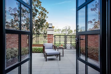 a chair and table outside with glass doors