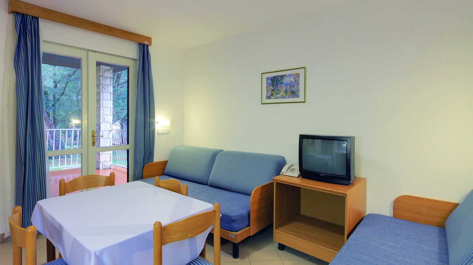 a room with a table and chairs and a television