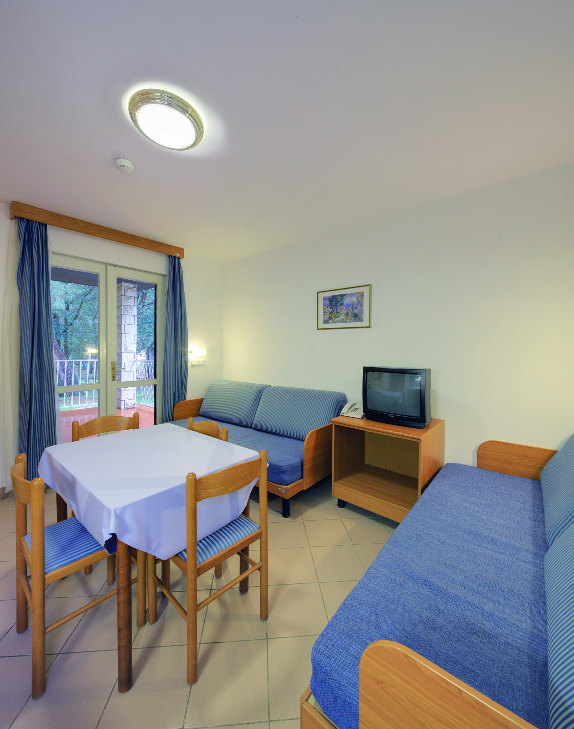 a room with a table and chairs and a television