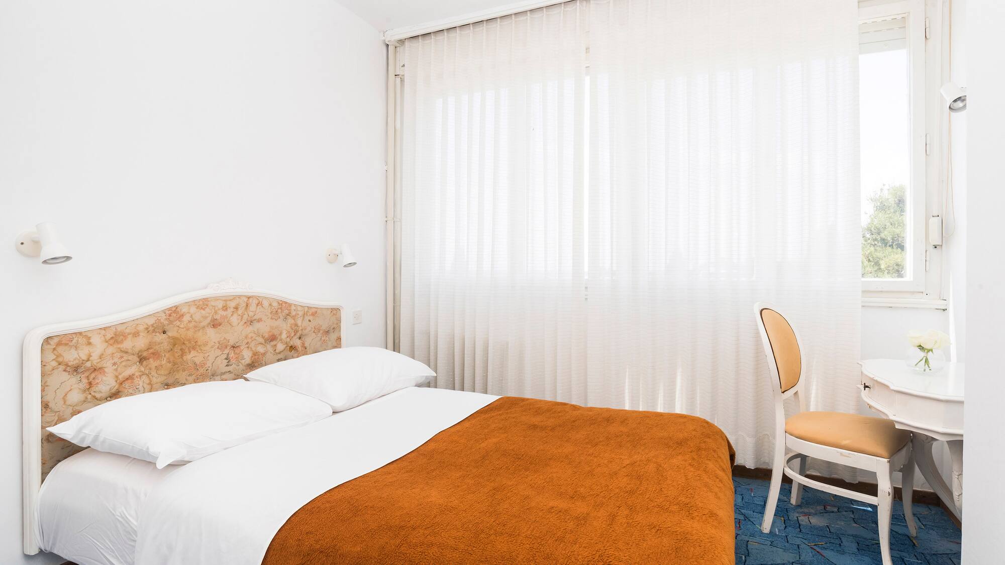 a bed with a chair and a chair in a room