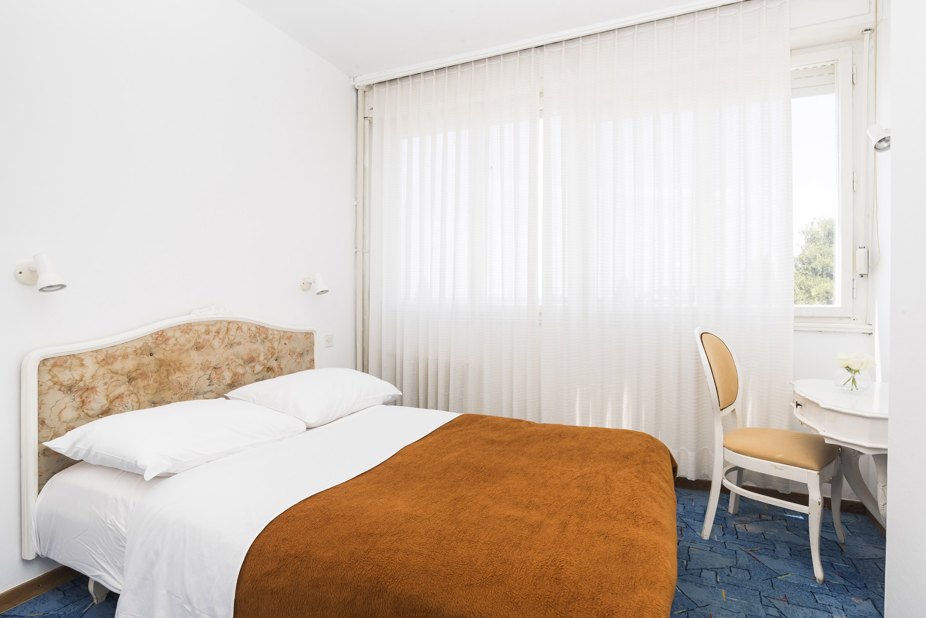 a bed with a chair and a chair in a room