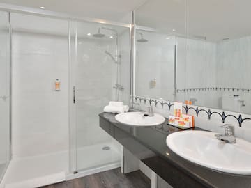 a bathroom with a shower and two sinks