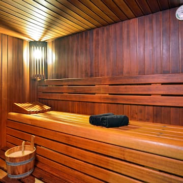 a wooden sauna with a bucket and a towel