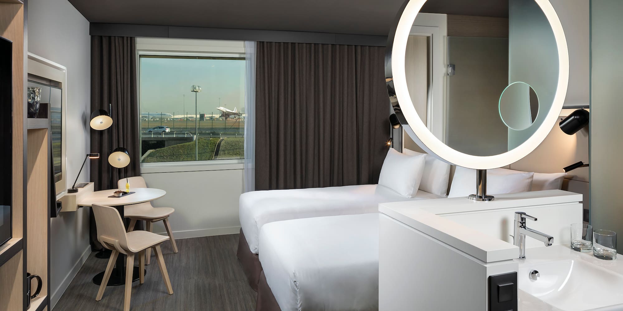 a room with two beds and a round light