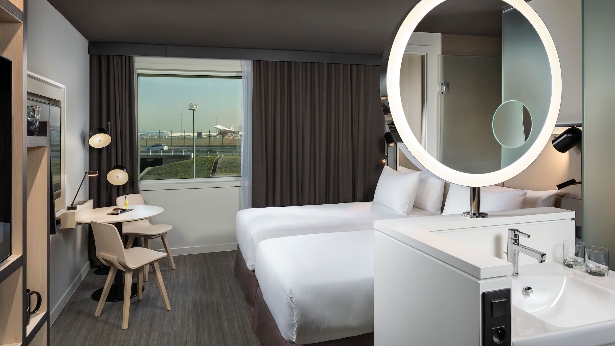 a room with two beds and a round light