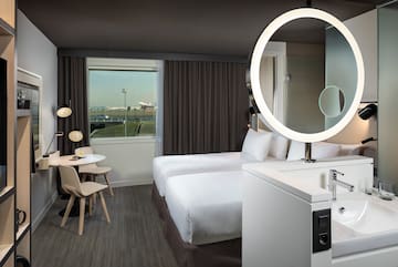 a room with two beds and a round light