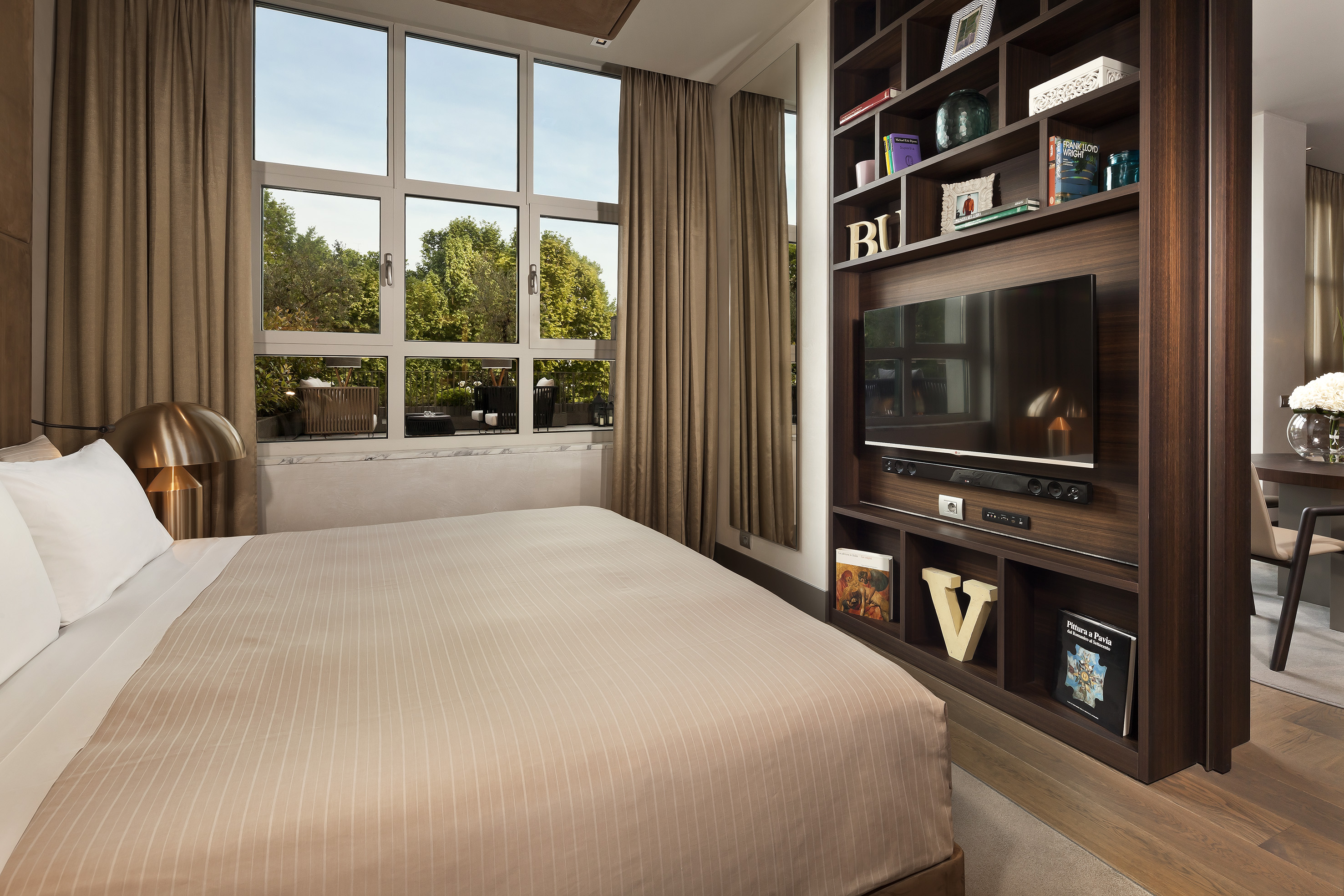 Contemporary bedroom with bed, garden view window, and built-in media unit.