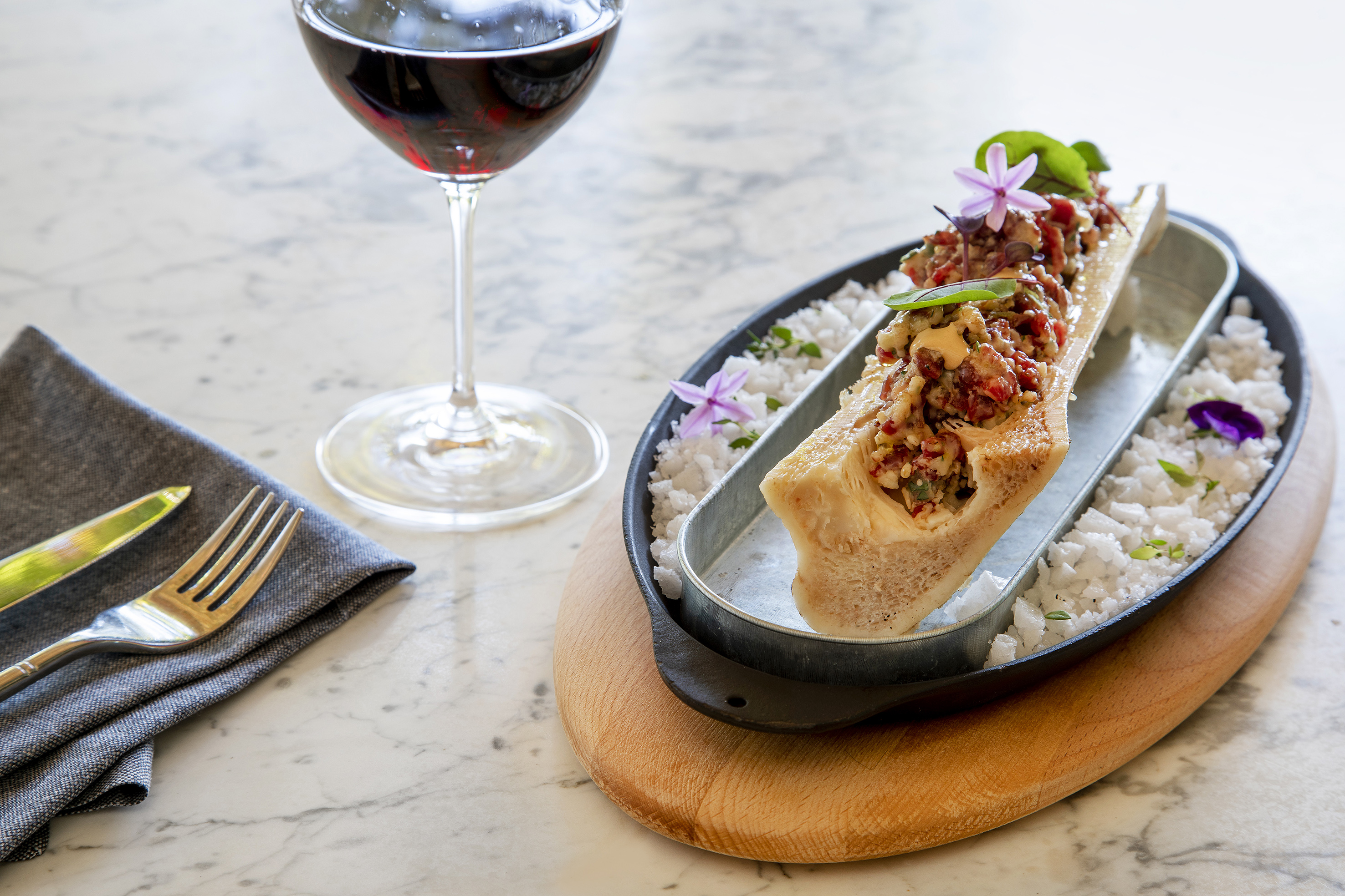 Roasted bone marrow with relish, red wine, salt. Gourmet dining dish.