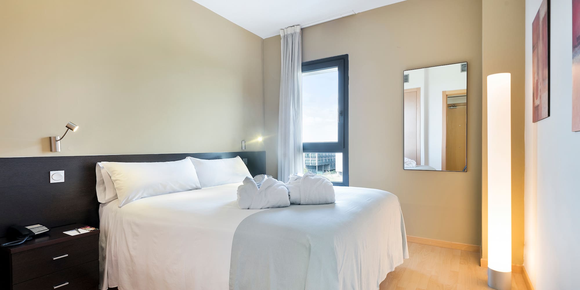 a bed with white sheets and towels on it