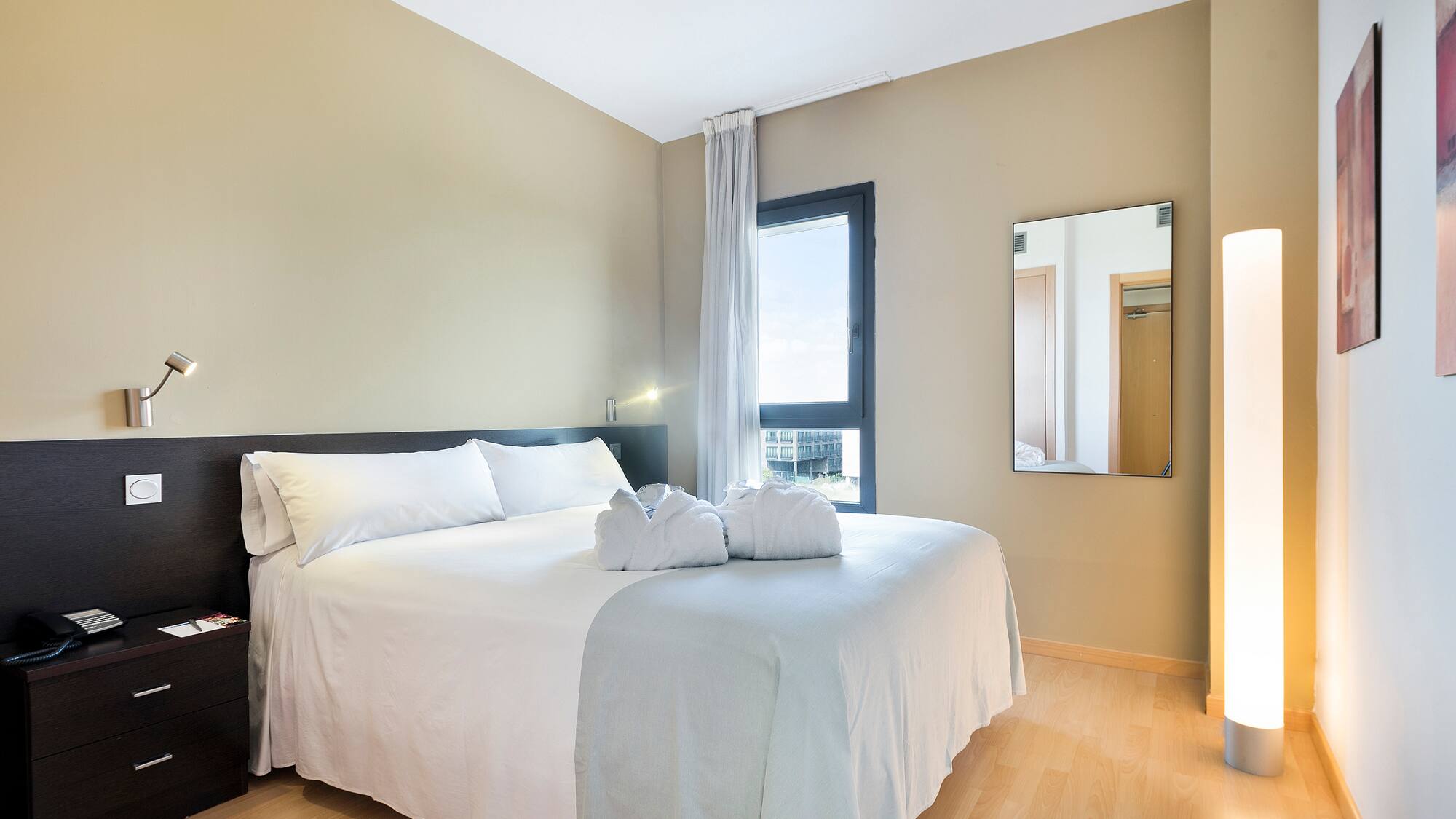 a bed with white sheets and towels on it