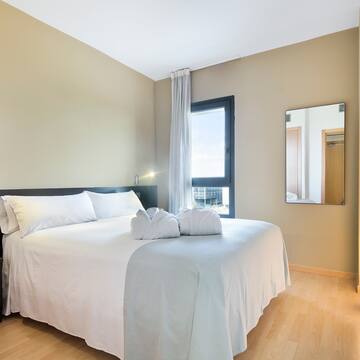 a bed with white sheets and towels on it