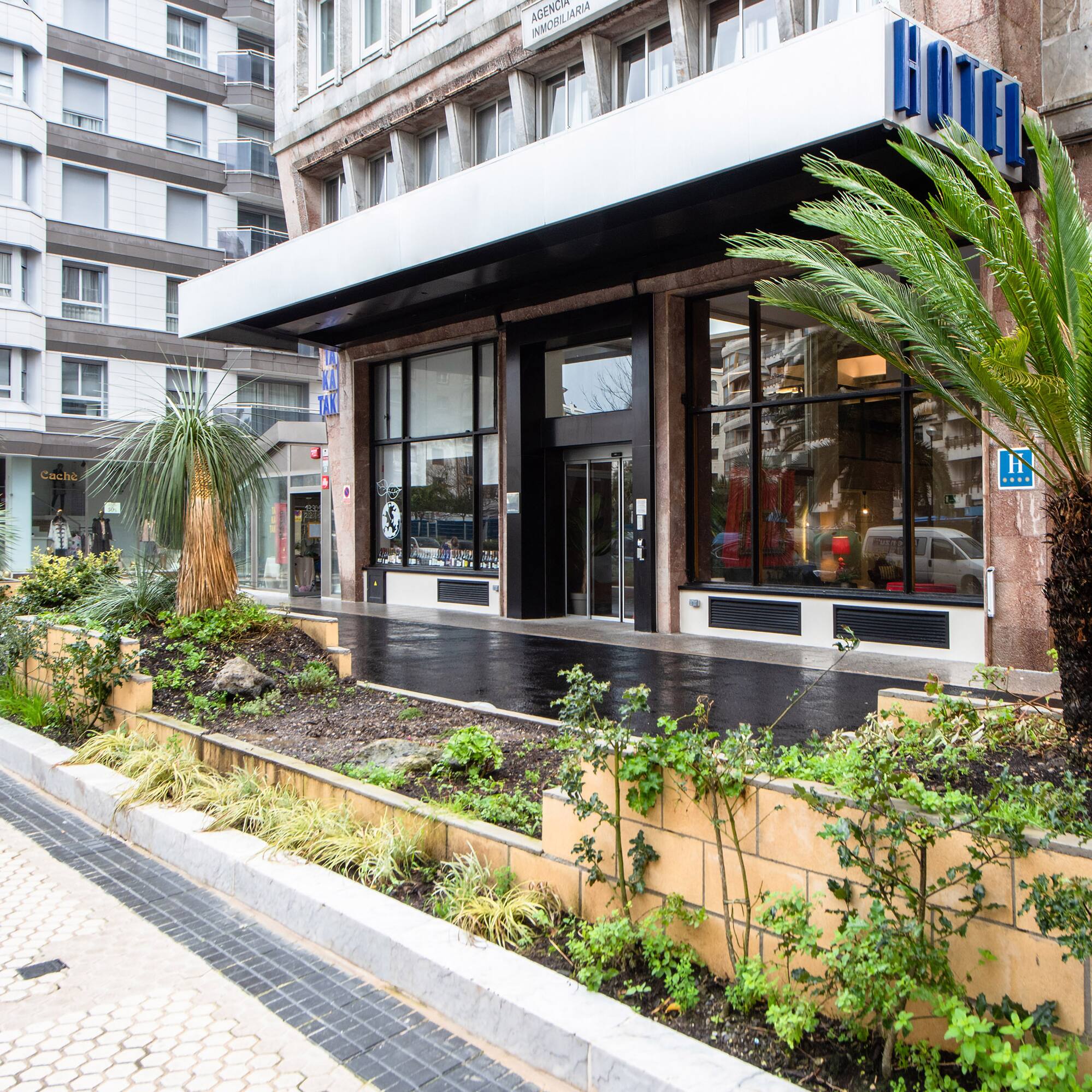 a hotel entrance with palm trees