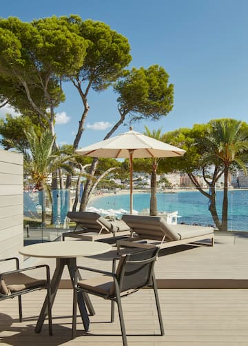 a deck with chairs and umbrellas by the water