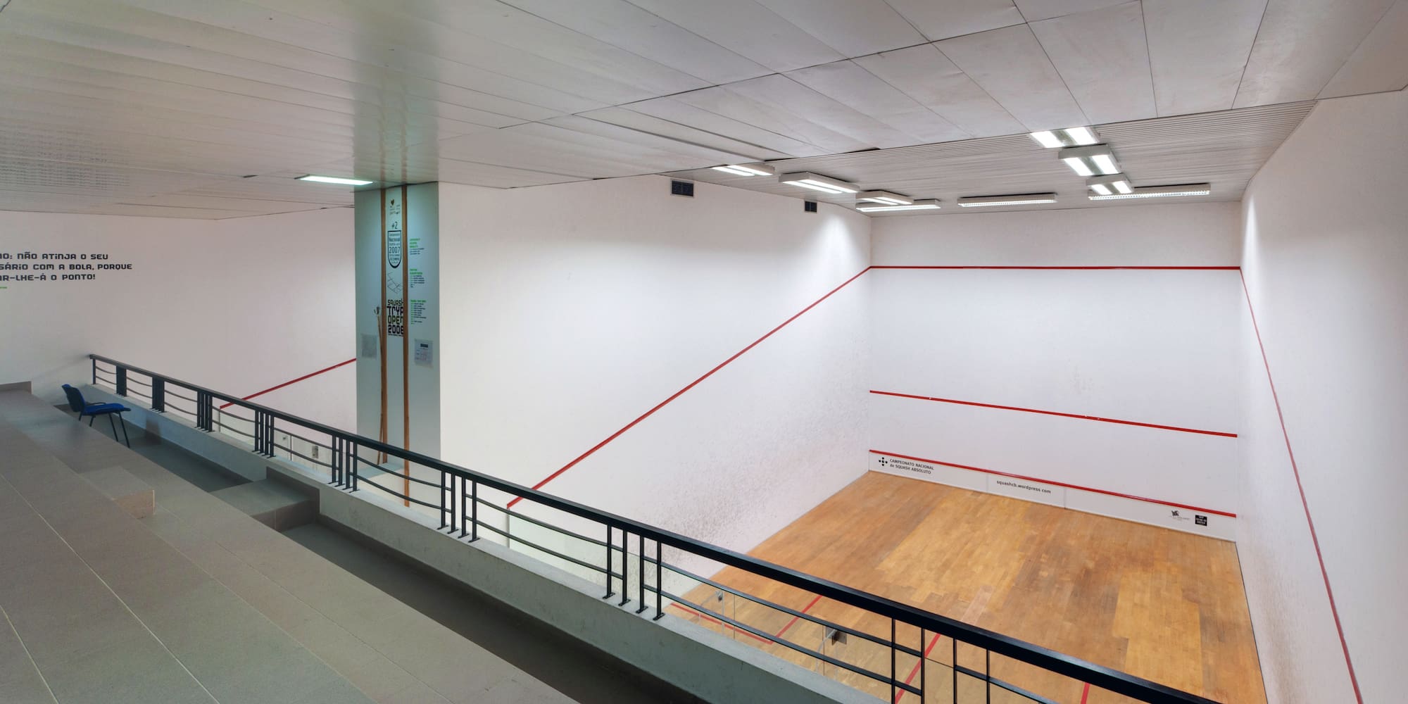 a tennis court with a wooden floor and a railing