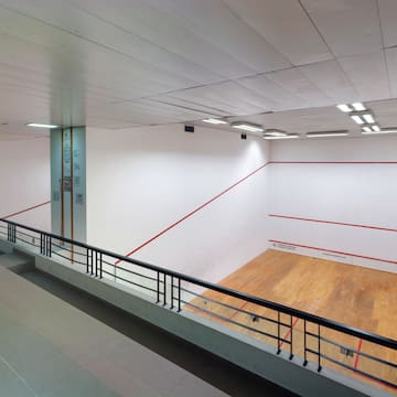 a tennis court with a wooden floor and a railing