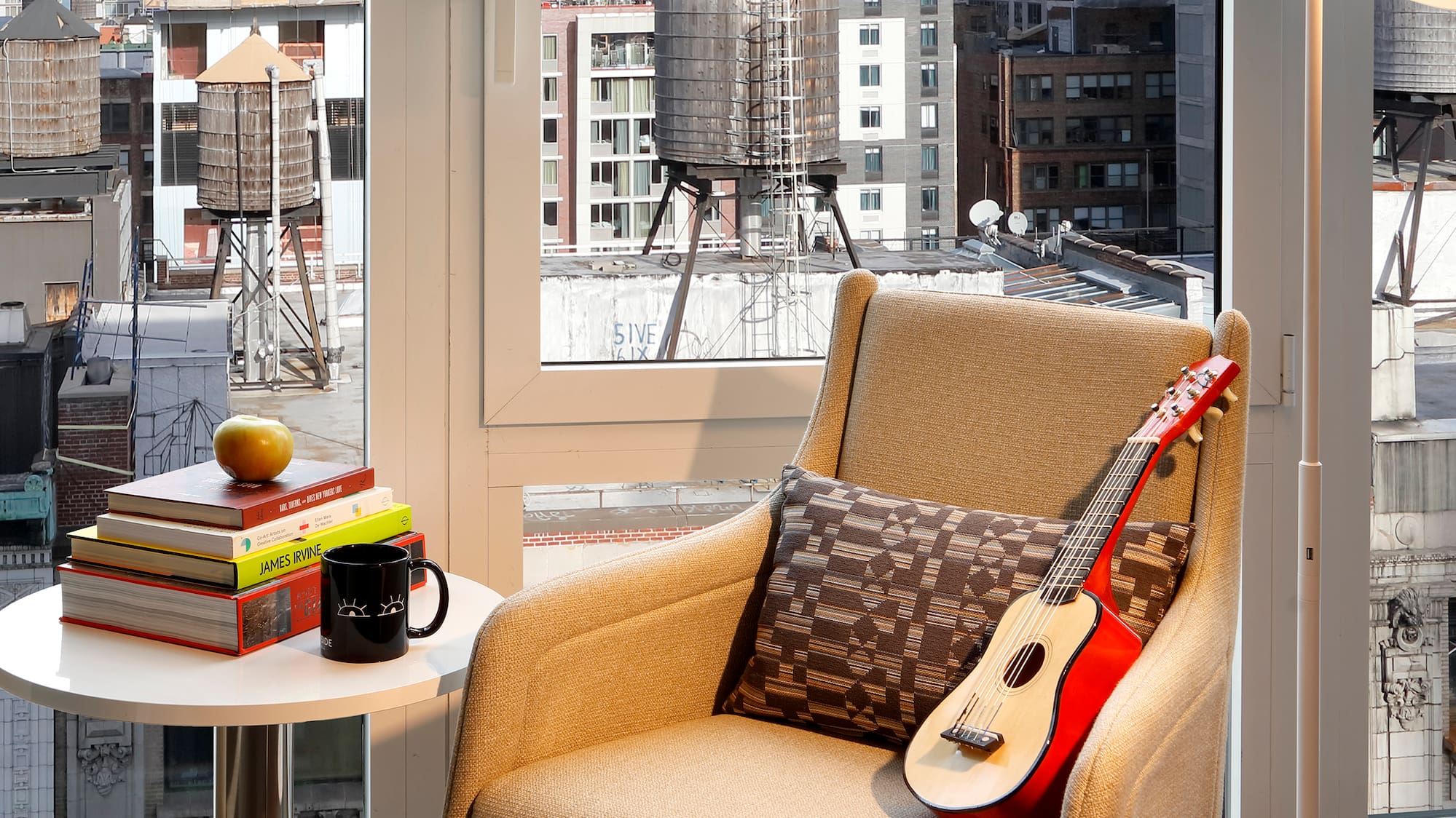 a guitar on a chair in front of a window