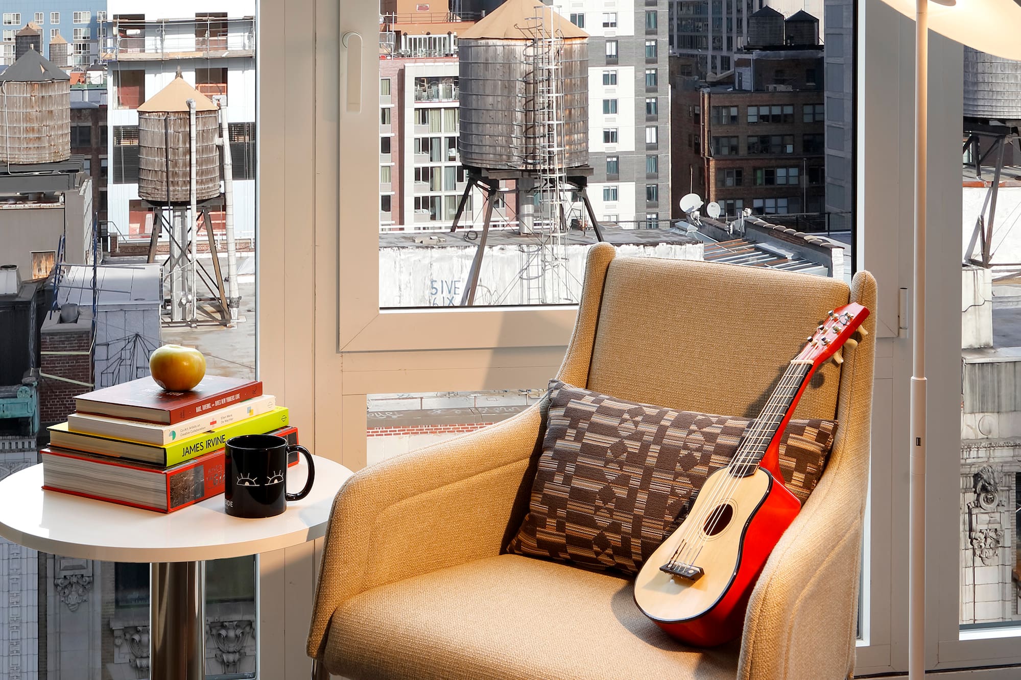 a guitar on a chair in front of a window