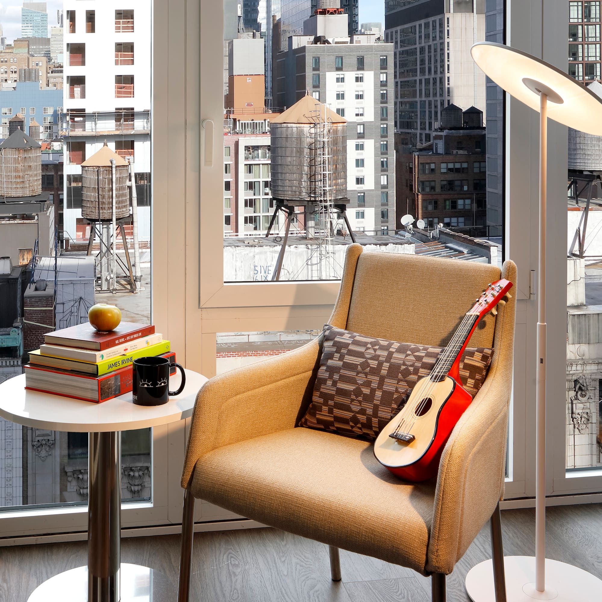 a guitar on a chair in front of a window