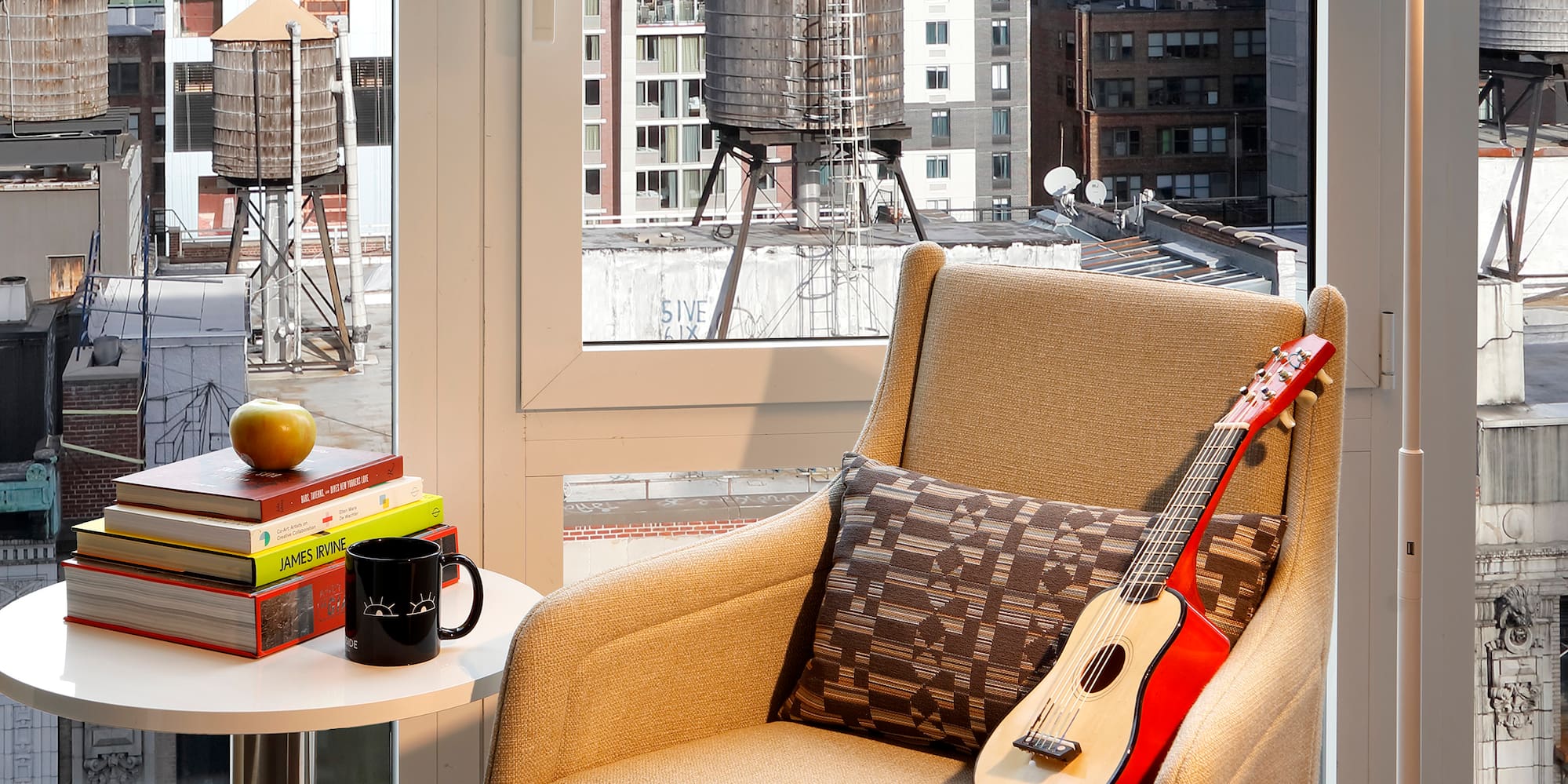 a guitar on a chair in front of a window