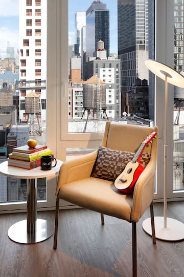 a guitar on a chair in front of a window