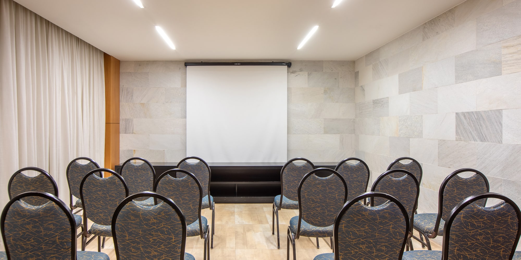 a room with chairs and a projector screen