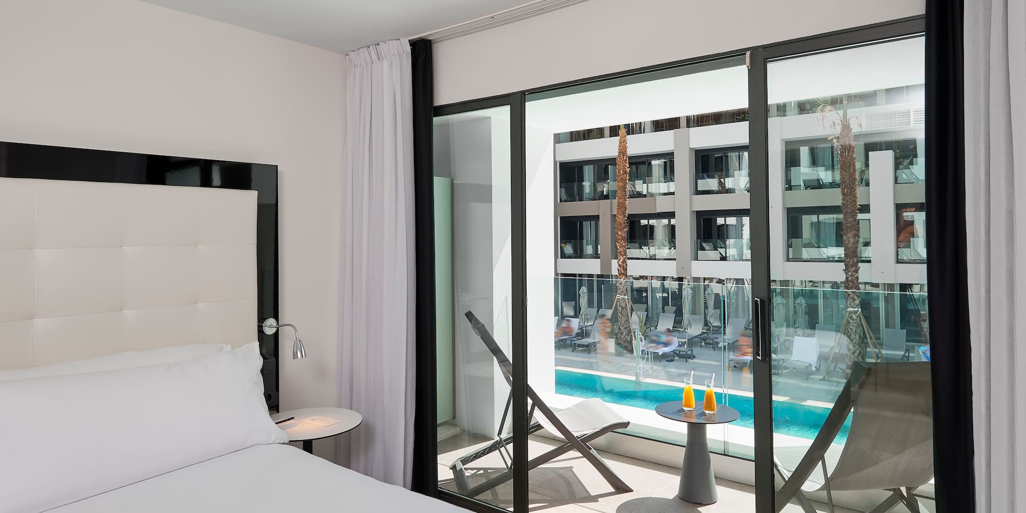 a bedroom with a glass door and a bed