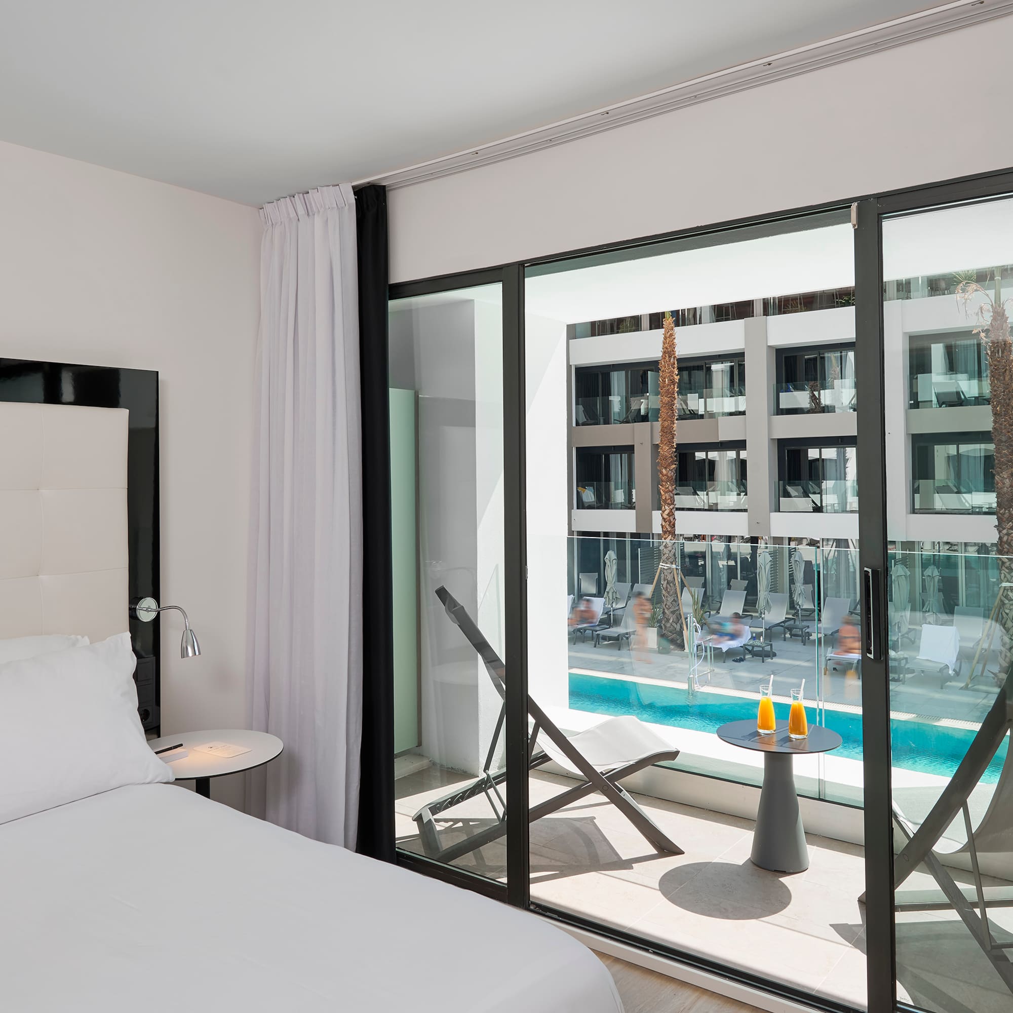 a bedroom with a glass door and a bed