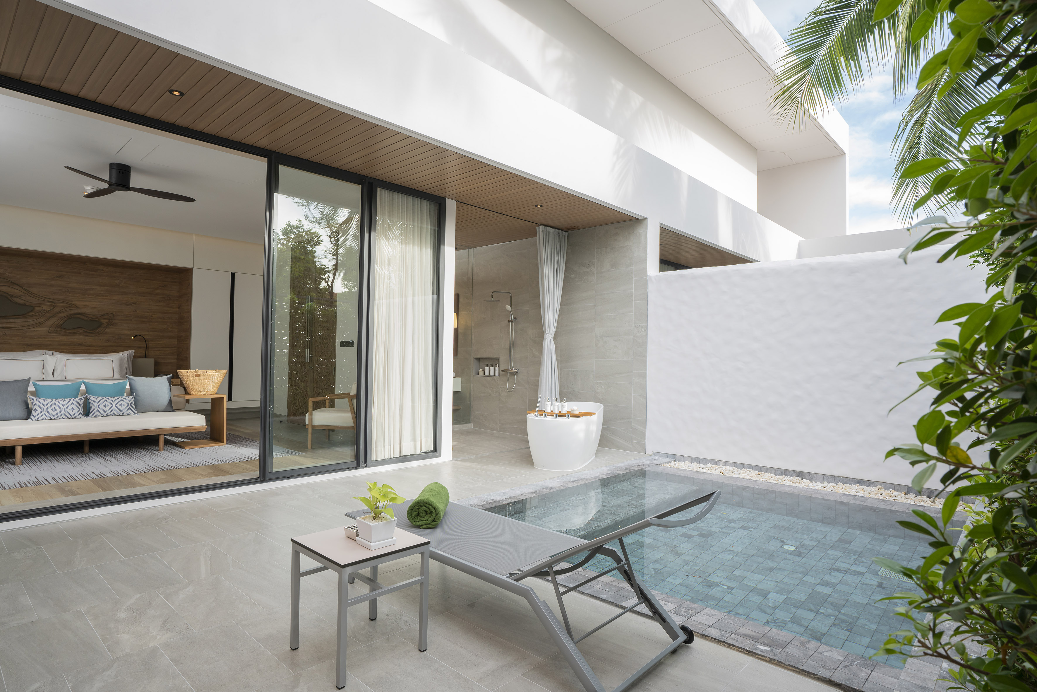 Luxury villa patio with private plunge pool, sun lounger, outdoor shower.