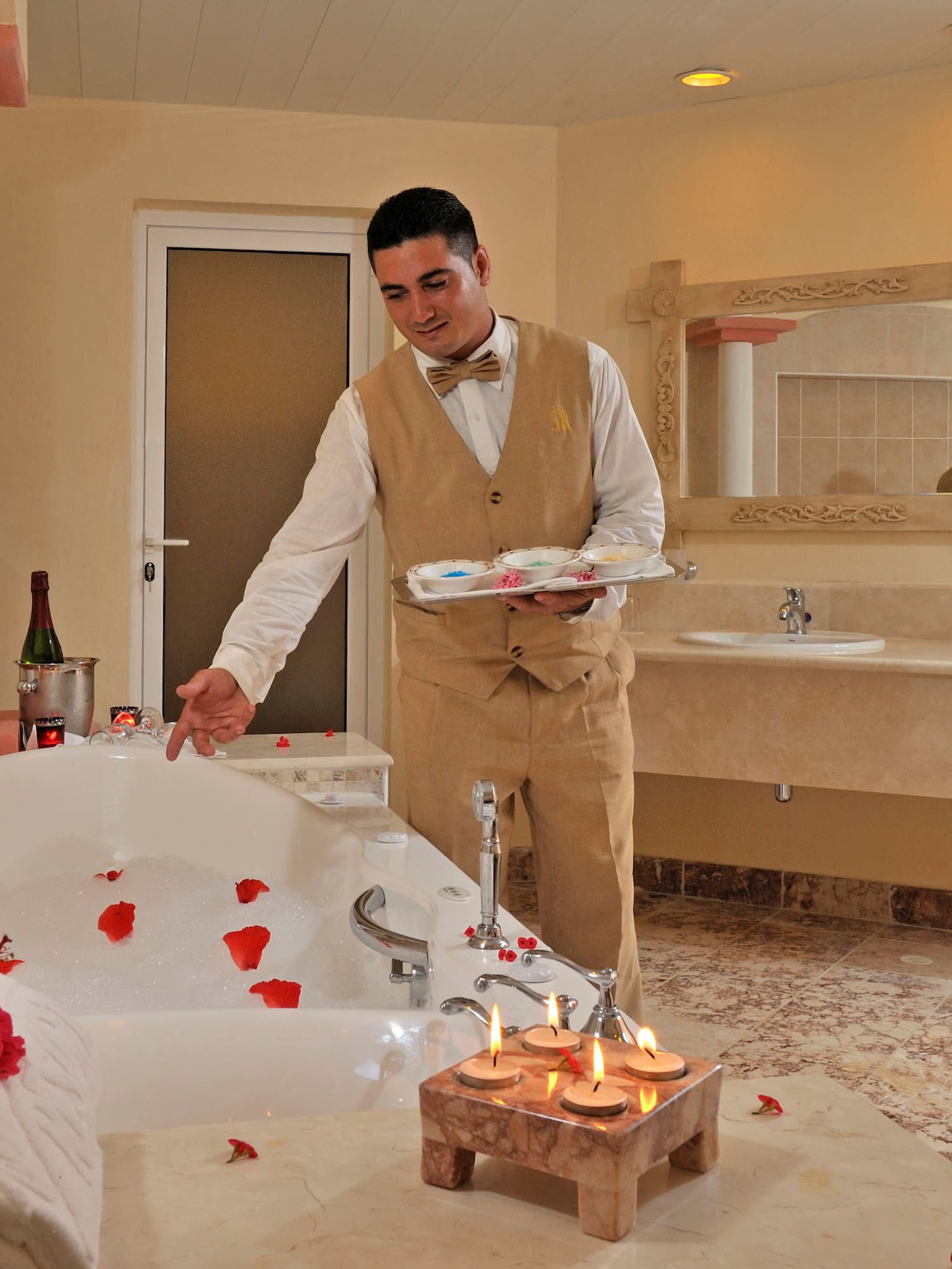 a man in a bathroom with a bathtub and rose petals