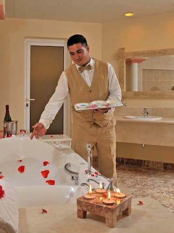 a man in a bathroom with a bathtub and rose petals