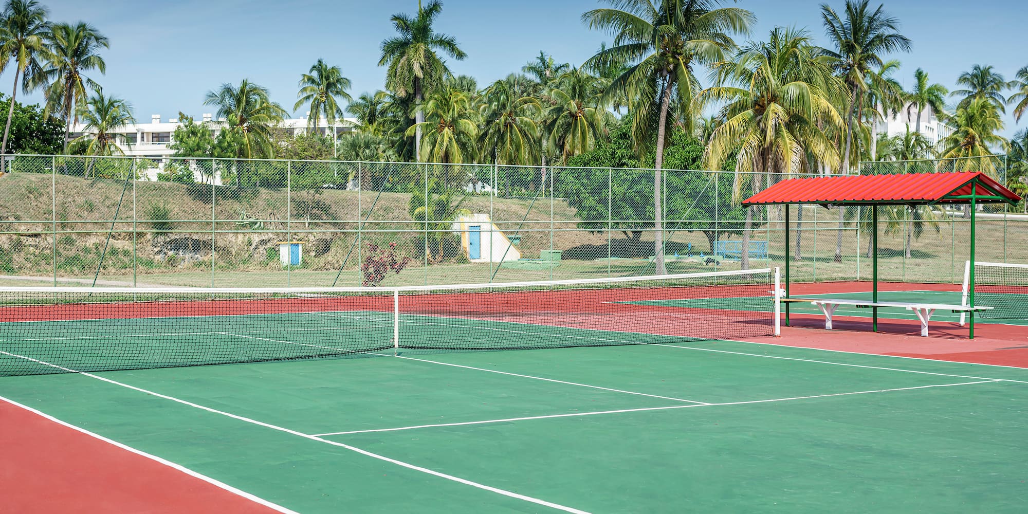 a tennis court with a red roof and a red gazebo