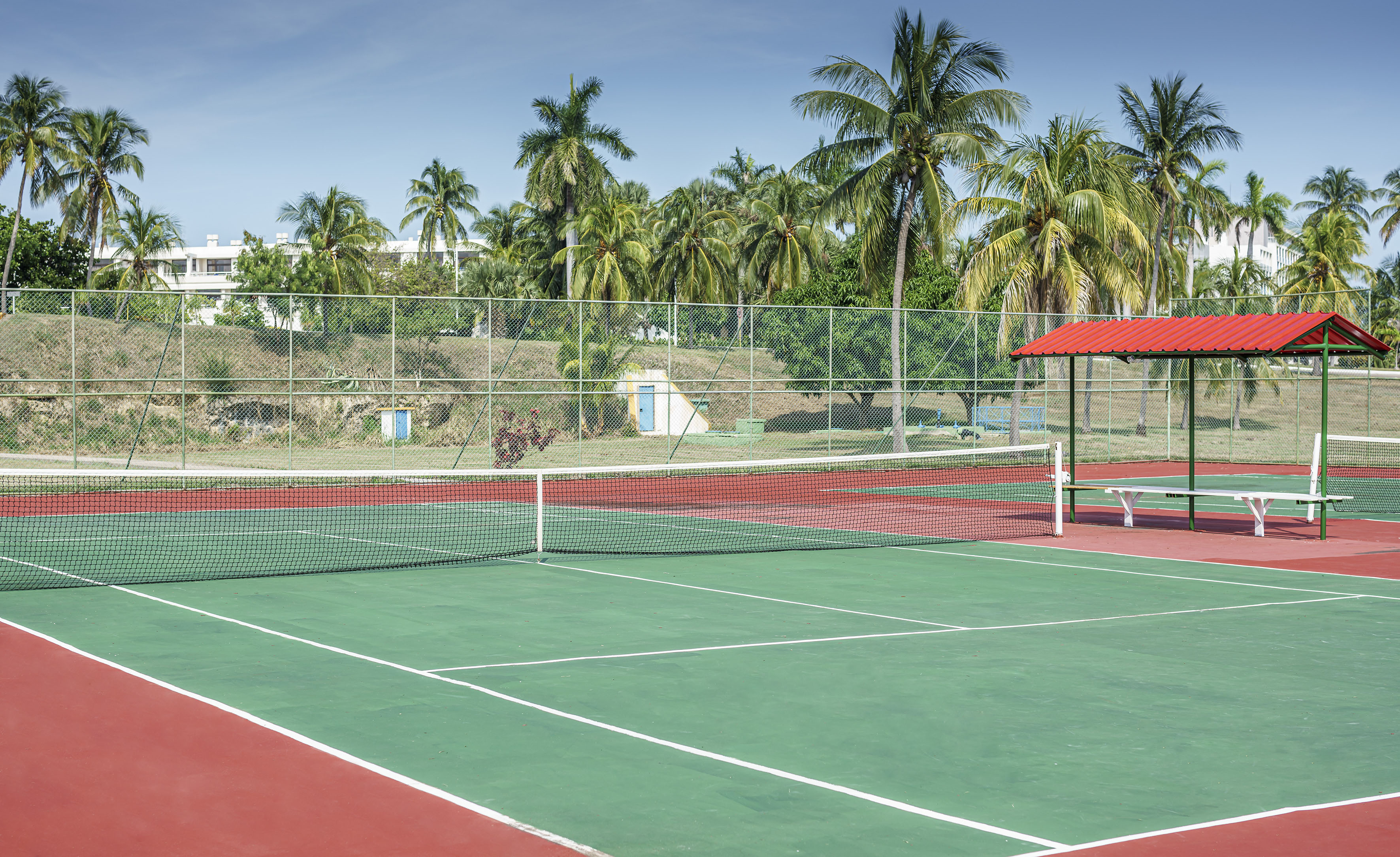 a tennis court with a red roof and a red gazebo