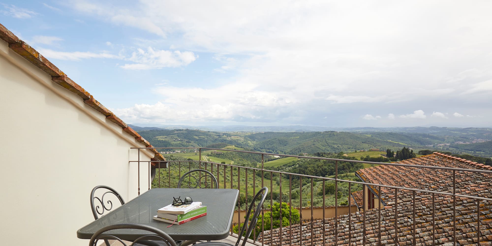 a table and chairs on a balcony overlooking a valley