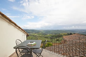 a table and chairs on a balcony overlooking a valley