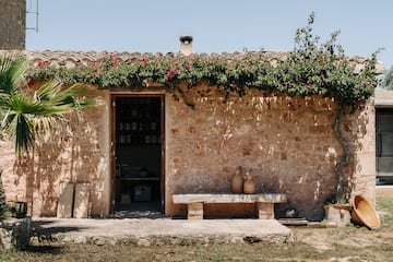 a stone building with a bench and vases